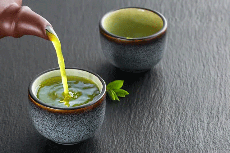 Japanese green tea being poured into a cup