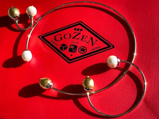 Gozen Enso pearl necklace with white and gold pearls on a red presentation box